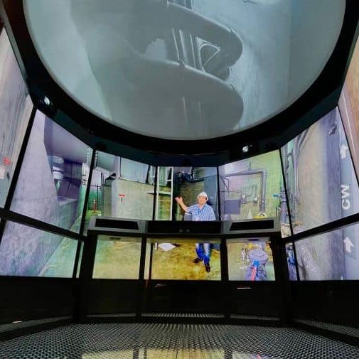 An overhead dome and curved portrait displays surround the Romero immersive exhibit